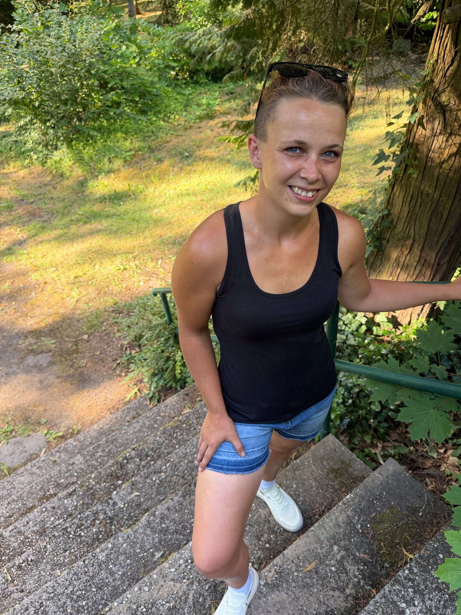 Anja von Kopflichtung geht lächelnd eine Treppe im Grünen hinunter, Symbolbild für den Alltagsservice